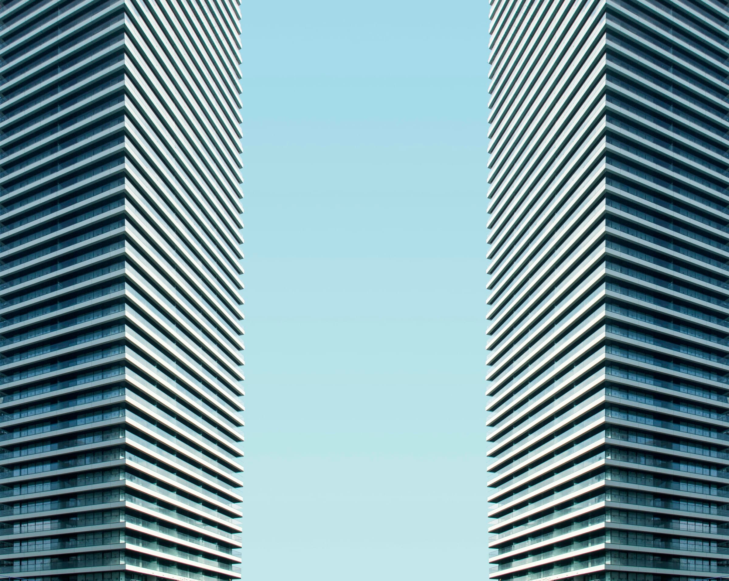 Two matching tower facades facing each other across a strip of sky
