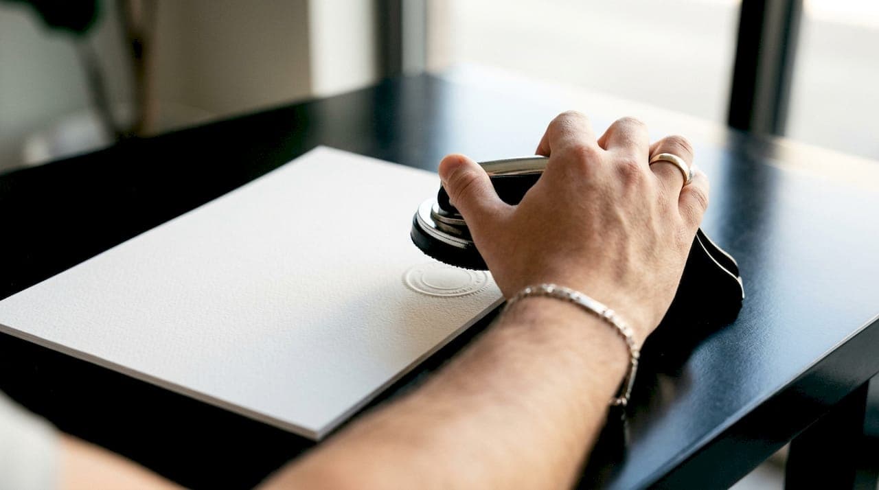 Embossed corporate seal being pressed on paper